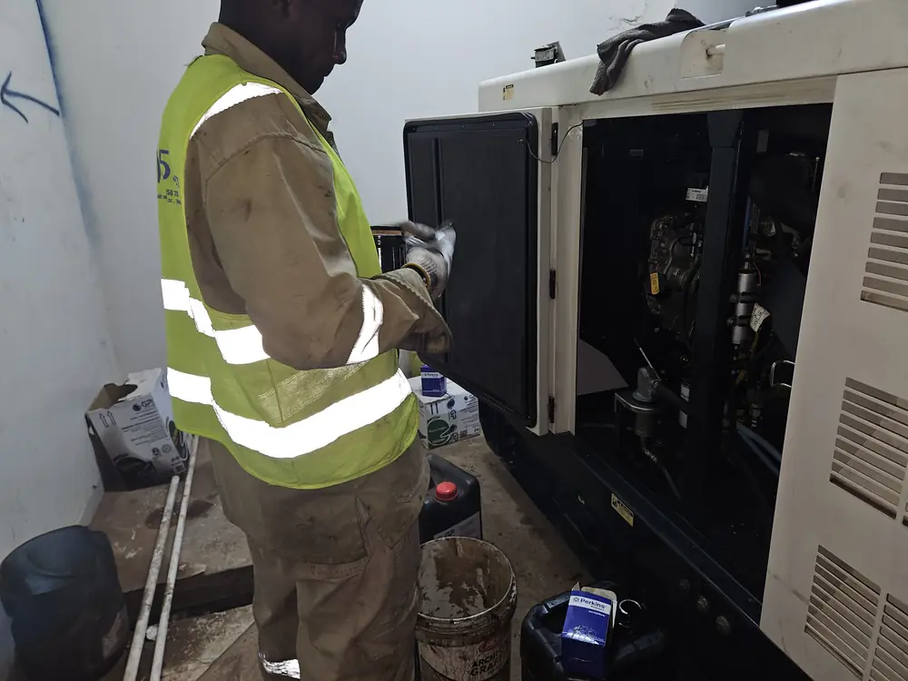 Technician carrying out scheduled maintenance on a standby generator
